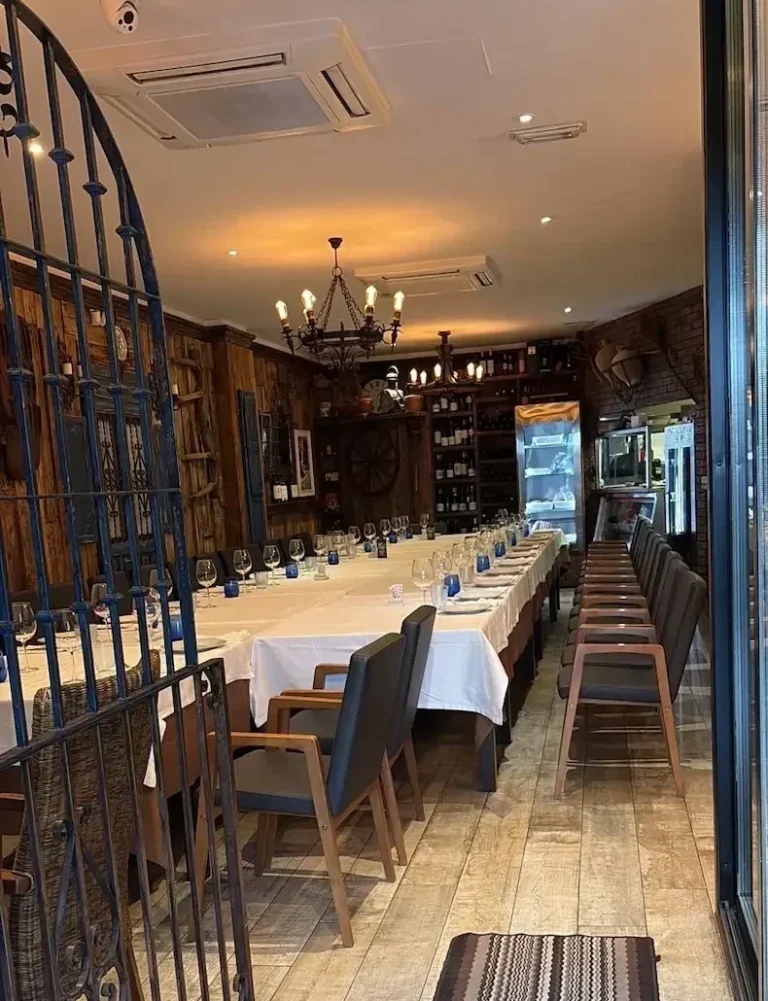Interior de salón de restaurante con mesas y sillas en un ambiente cálido de parrilla uruguaya