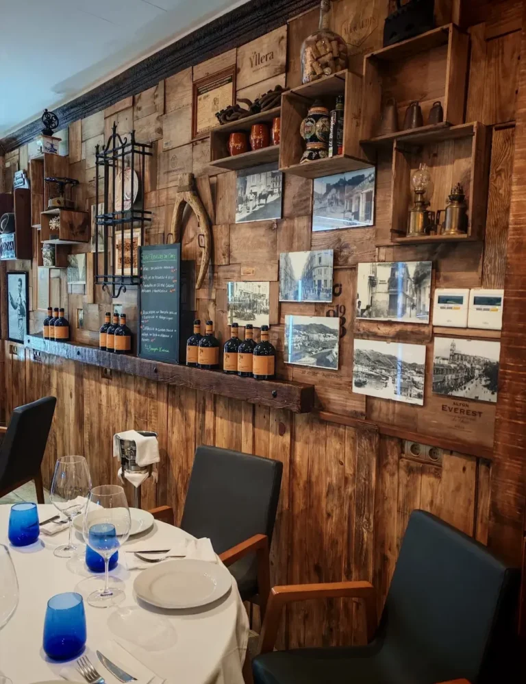 Interior de un restaurante de parrilla uruguayo con carnes a la brasa y ambiente cálido rústico.